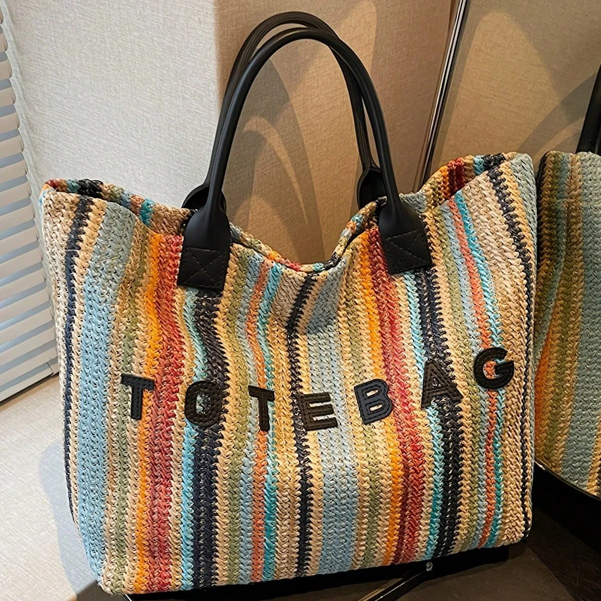 This stylish, colorful striped straw tote bag features a bohemian-style handwoven letter pattern and contrasting colors. A versatile and simple shoulder bag, perfect for summer beach vacations, everyday outings, or shopping.